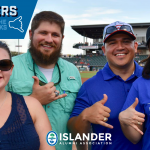 Islander alumni posing for a shakas up group photo on the field at a hooks game!
